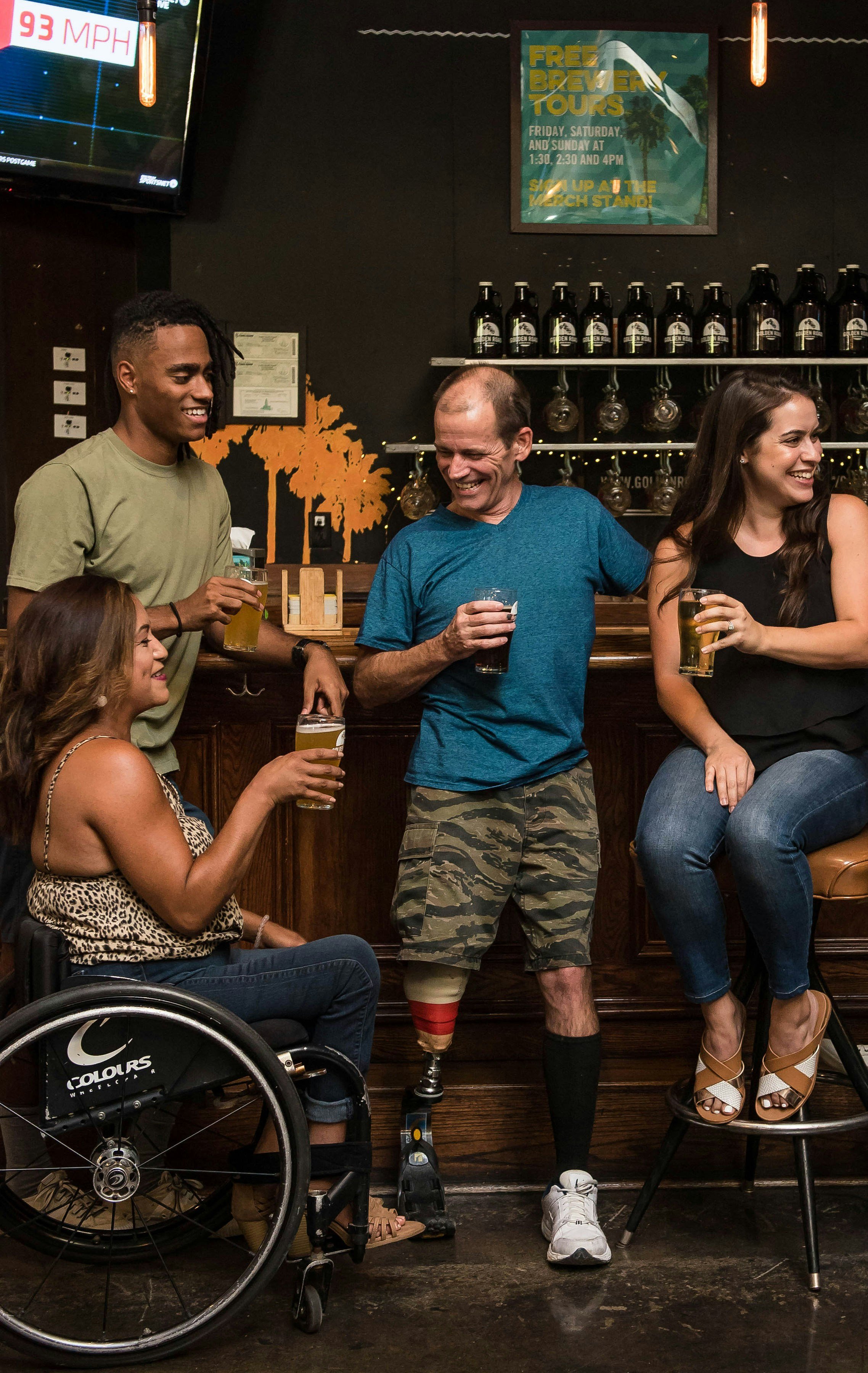 Group of people in a bar, one of them is a wheelchair user