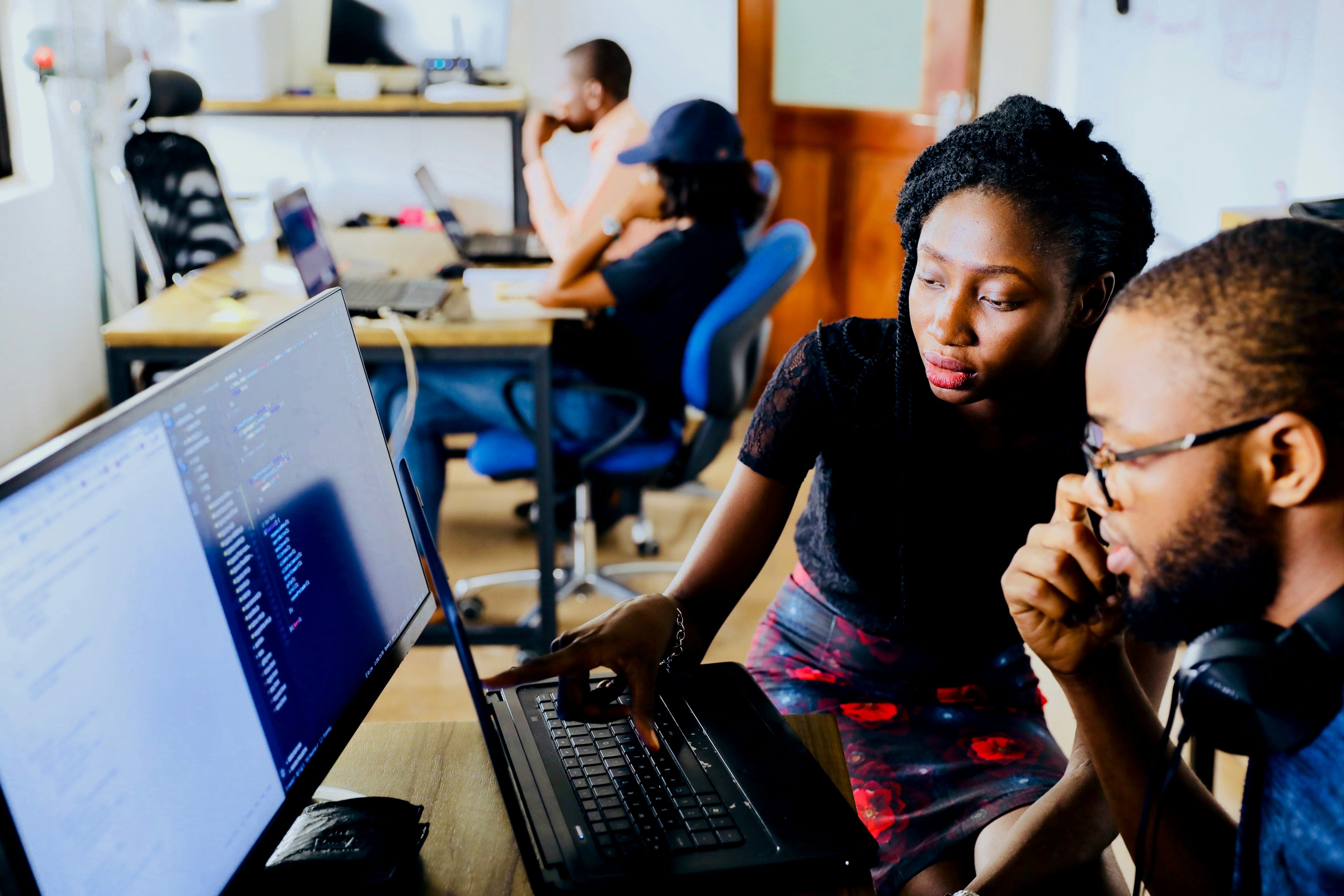 two persons sitting in front of computer