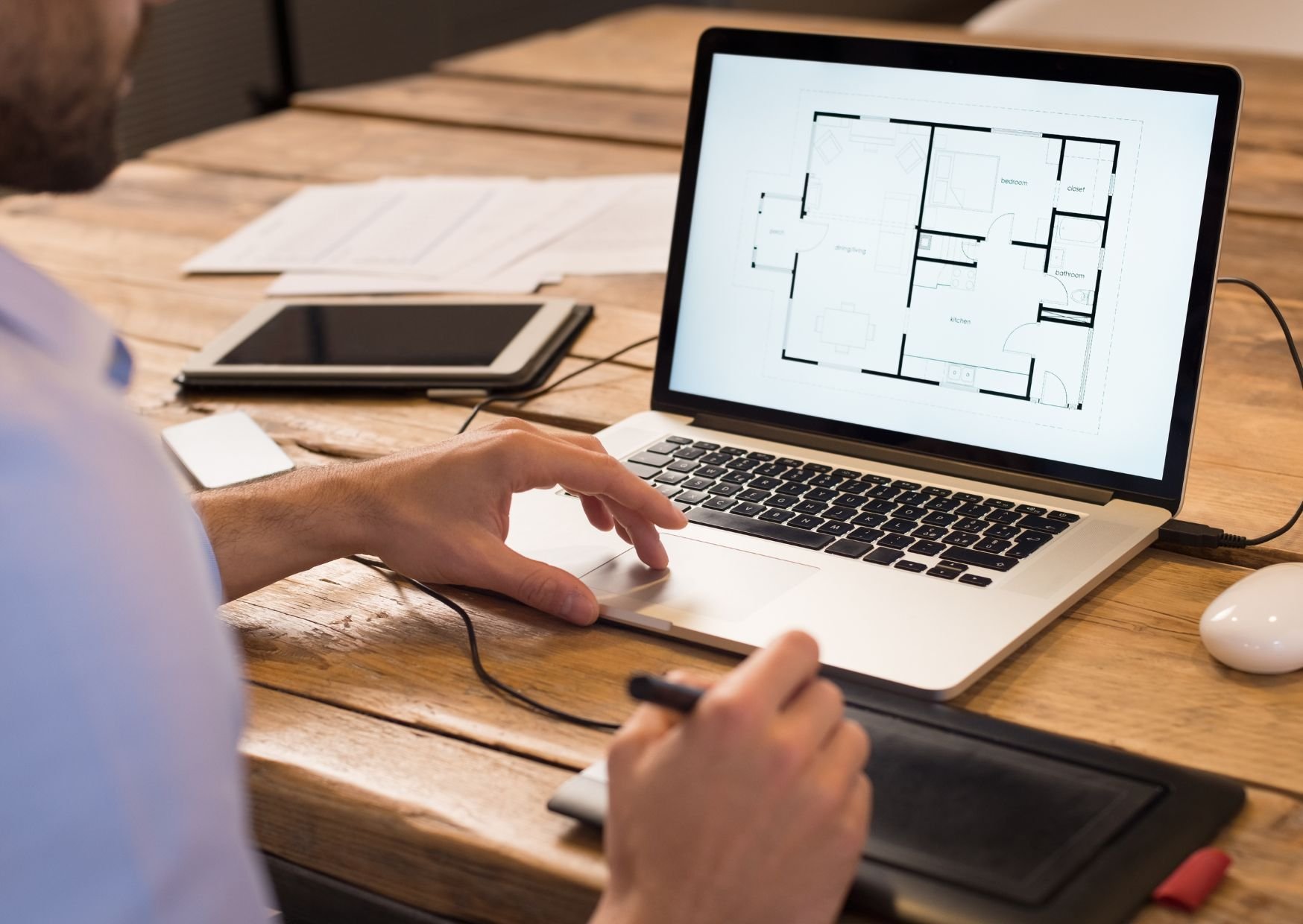 man working on laptop checking a design plan