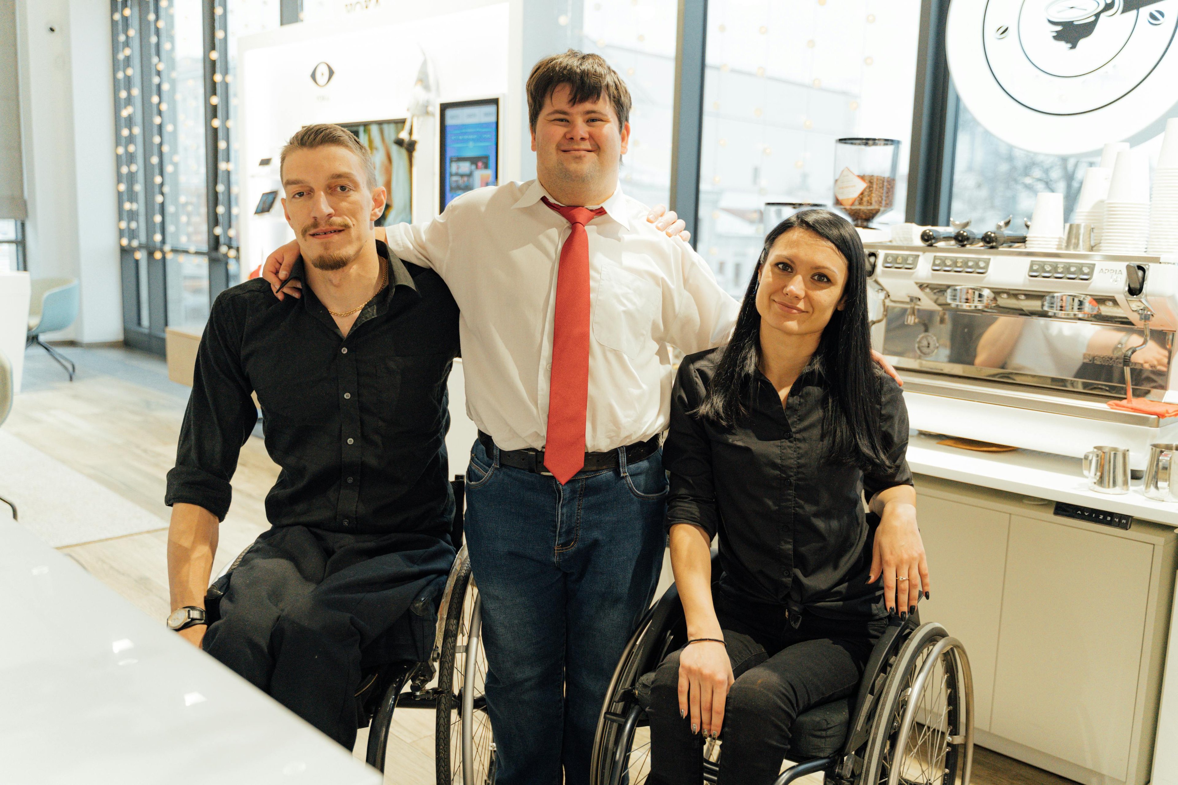 3 persons - one guy with Down syndrome, and a girl and a guy who are using wheelchairs